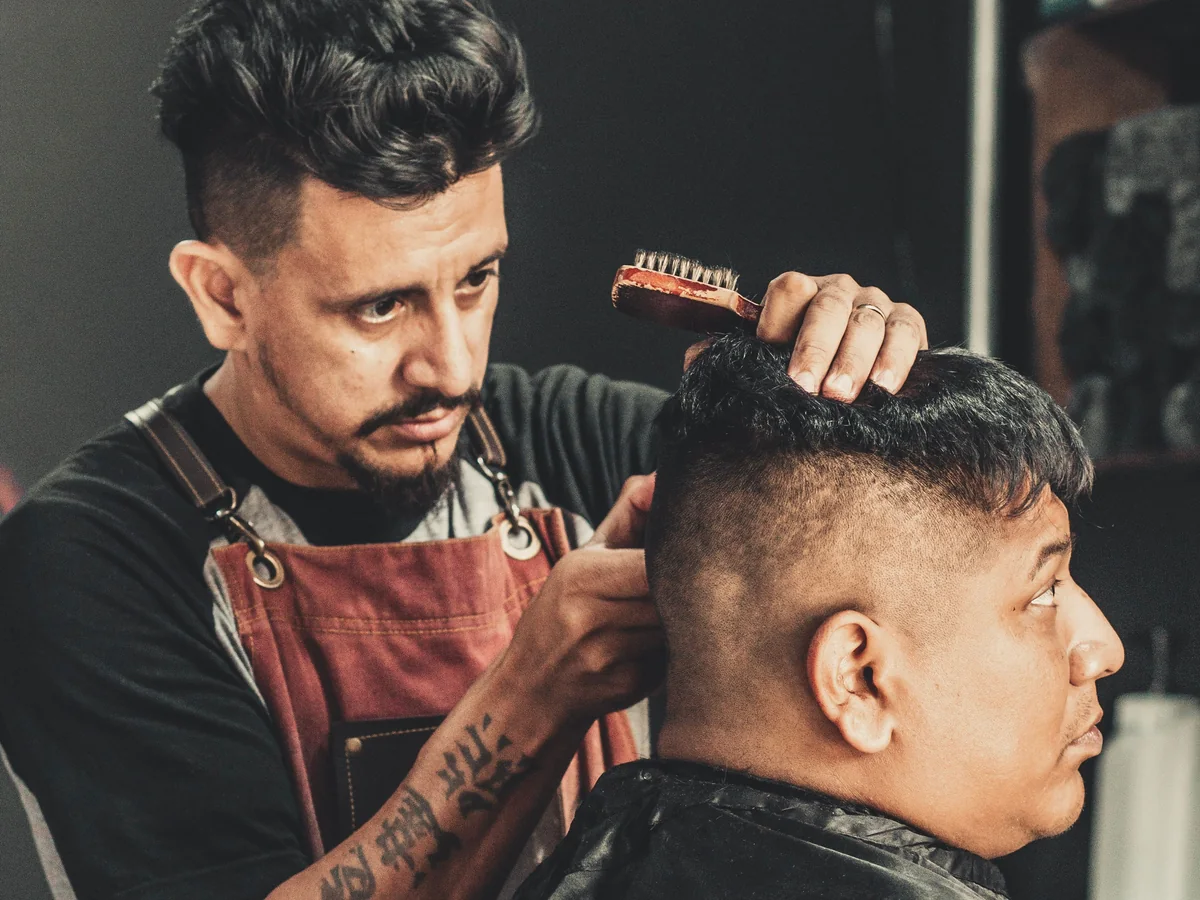 Barber giving a client a close fade haircut